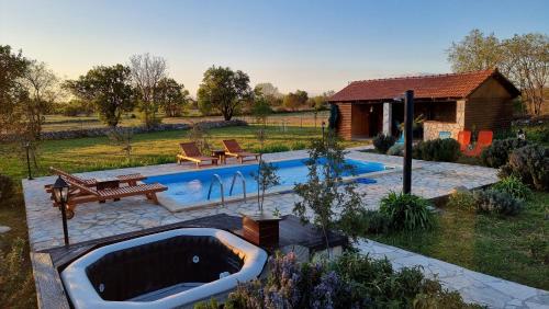 a swimming pool with a bath tub in a yard at Villa Stone Medal in Drniš