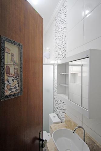 a bathroom with a sink and a mirror at Recanto Villa REAL in Olímpia