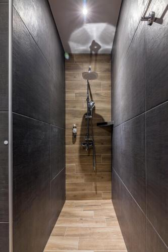 a walk in shower in a bathroom with wooden walls at Raise Kornarou City Stay in Heraklio Town
