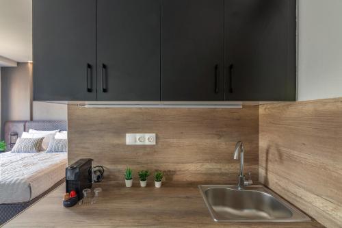 a kitchen with a sink and a bed at Raise Kornarou City Stay in Heraklio Town