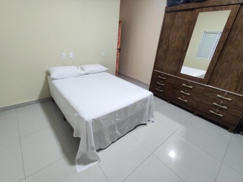 a bedroom with a bed and a dresser and a mirror at Casa Canastra Bio in São Roque de Minas