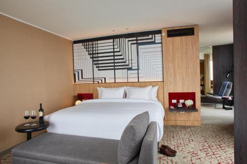 a bedroom with a large white bed and a chair at Pullman Lima Miraflores in Lima