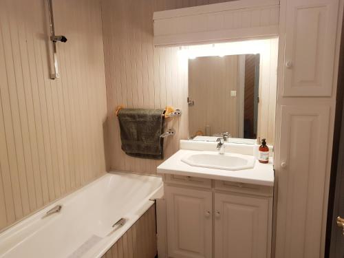 La salle de bains blanche est pourvue d'un lavabo et d'une baignoire. dans l'établissement Suite 53m2 - Appartement privé - Grand Paris, à Noisy-le-Sec