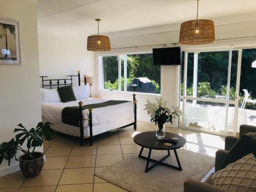 a bedroom with a bed and a living room at Serendipity Adorable Tairua Studio in Tairua