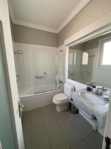 y baño con aseo, bañera y lavamanos. en Hotel Casa SOMERSCALES, en Valparaíso