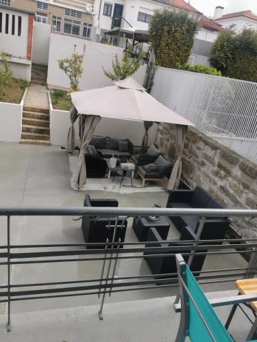 a patio with a white umbrella and chairs and tables at Angel by Prada City House in Vila Nova de Gaia