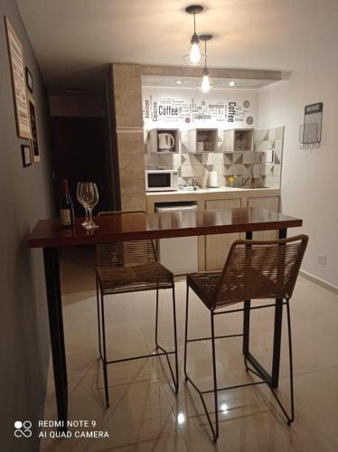 eine Küche mit einem Tisch, 2 Stühlen und einer Theke in der Unterkunft Mágnum Apartments Studio in Mendoza