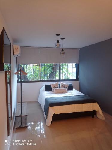 ein Schlafzimmer mit einem Bett und einem großen Fenster in der Unterkunft Mágnum Apartments Studio in Mendoza