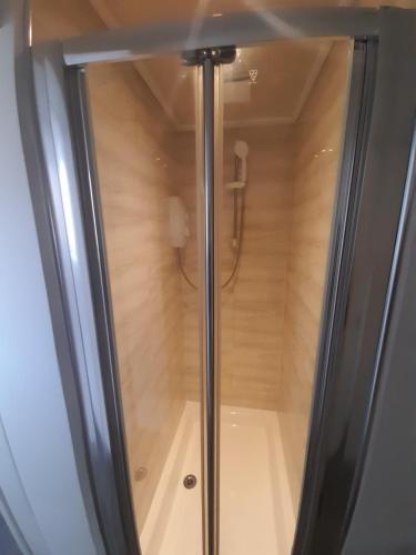 baño con cabina de ducha de cristal y suelo de madera en Melverley House, en Mánchester