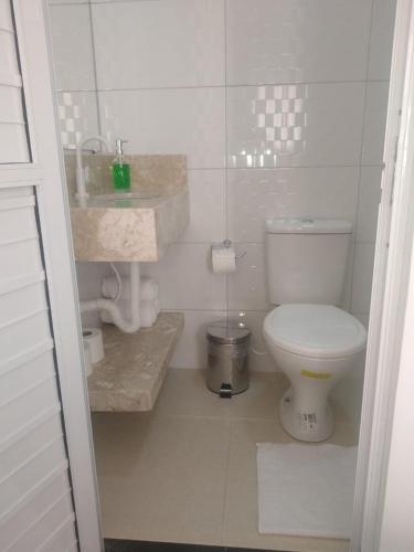 Pousada Parque das Águas في توكانو: حمام ابيض مع مرحاض ومغسلة