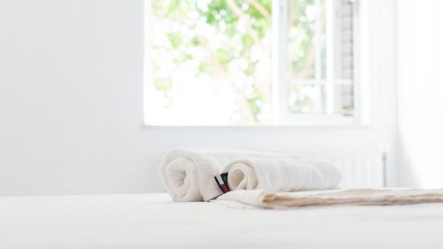 a pile of towels sitting on a window sill at Aegean Touch Beach House in Artemida