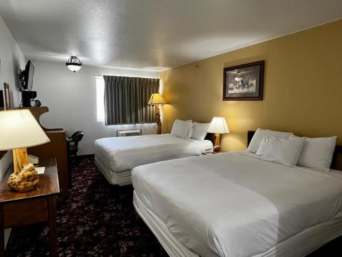 a hotel room with two beds and a window at Buffalo Bill's Antlers Inn in Cody