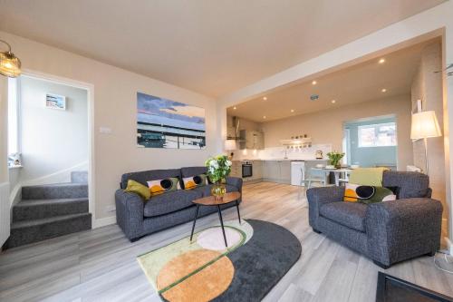 a living room with two couches and a table at Harbour View Cottage in Watchet