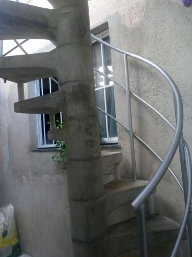 a spiral staircase in a building with a window at Kitnet mobiliado, confortável e bem localizado. in Fortaleza