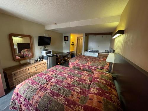 a hotel room with two beds and a mirror at Circle 6 Motel in Weyburn