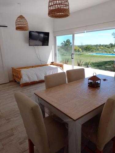 a living room with a dining room table and a bed at Los colibries in San Pedro