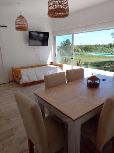 Una sala de estar con una mesa de comedor y una cama. en Los colibries, en San Pedro