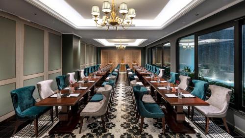 a row of tables and chairs in a room with windows at Peridot Grand Luxury Boutique Hotel in Hanoi