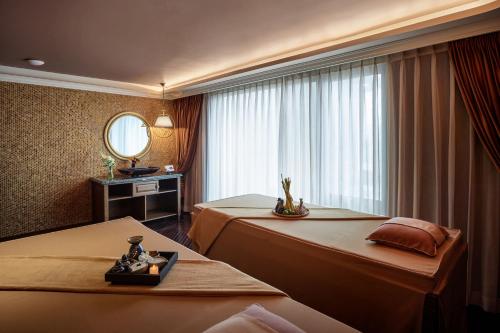 a hotel room with two beds and a mirror at Peridot Grand Luxury Boutique Hotel in Hanoi