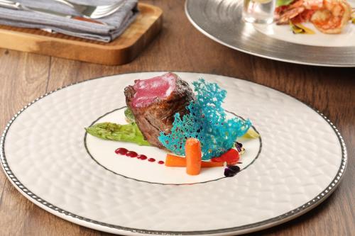 a piece of cake on a white plate on a table at Peridot Grand Luxury Boutique Hotel in Hanoi