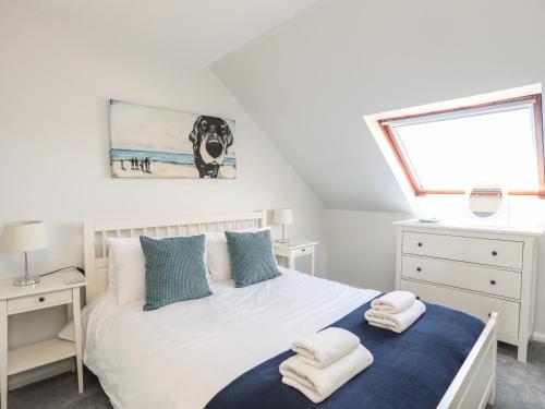 a bedroom with a bed with a dog picture on the wall at Isallt Cove in Trearddur