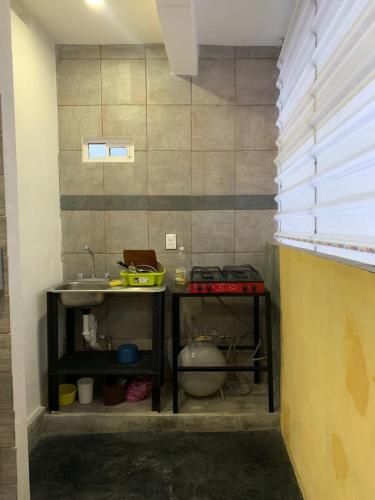 eine Küche mit 2 Tischen und einem Waschbecken in der Unterkunft verde amanecer in Xilitla