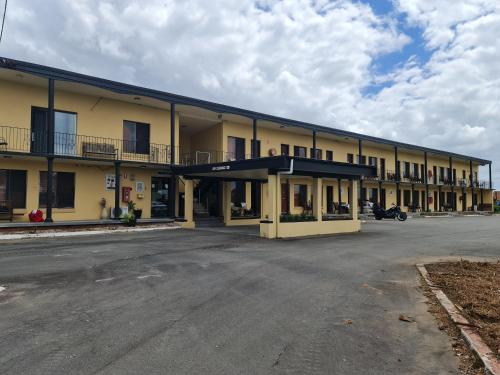 an empty parking lot in front of a building at Country Plaza Motel Taree in Taree