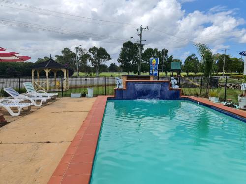 a swimming pool with a gazebo and a playground at Country Plaza Motel Taree in Taree
