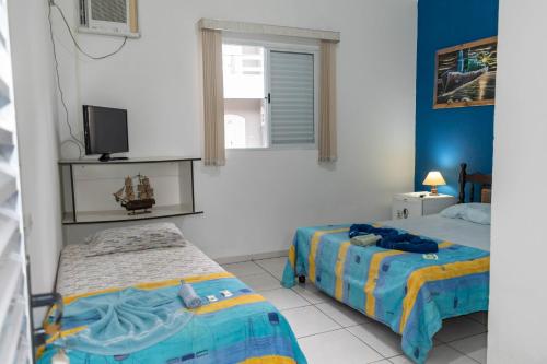 a bedroom with two beds and a window at Hotel Marina Clube de Pesca in Cananéia