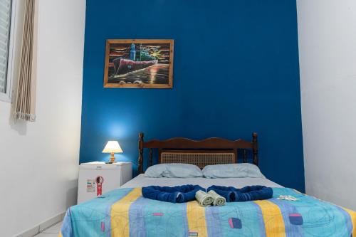 a blue bedroom with a bed with a blue wall at Hotel Marina Clube de Pesca in Cananéia