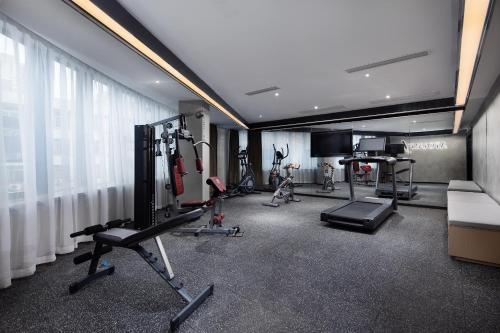 a gym with several treadmills and machines in a room at Atour Hotel Changsha Wangcheng District in Changsha
