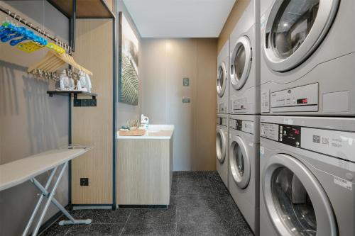 a laundry room with a washer and dryer at Atour Hotel Xishuangbanna Jinghong Gaozhuang Starlight Night Market in Jinghong