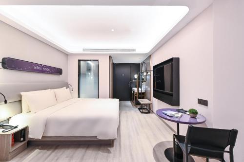 a hotel room with a bed and a tv at Atour Light Hotel Jilin Xiamen Street in Jilin