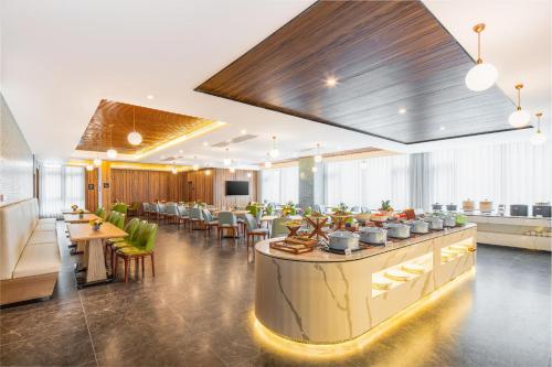 a restaurant with a bar and tables and chairs at Atour X Hotel Xian Administration Center of North Railway Station in Xi'an