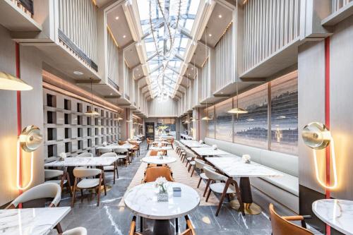 a restaurant with tables and chairs and a ceiling at Atour Hotel Yuzhong Yuci Incity in Jinzhong