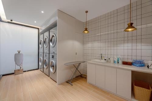 a laundry room with a row of washing machines at Atour Hotel Nanning Wuxiang Headquarter Base in Nanning