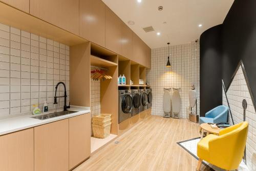 a kitchen with a sink and a yellow chair at Atour Hotel Shangxing Lu Xun s Hometown in Shaoxing