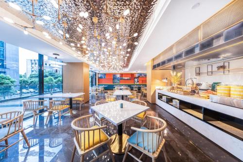 a restaurant with tables and chairs and a chandelier at Atour Hotel Guiyang Guanshan Lake City Government in Guiyang