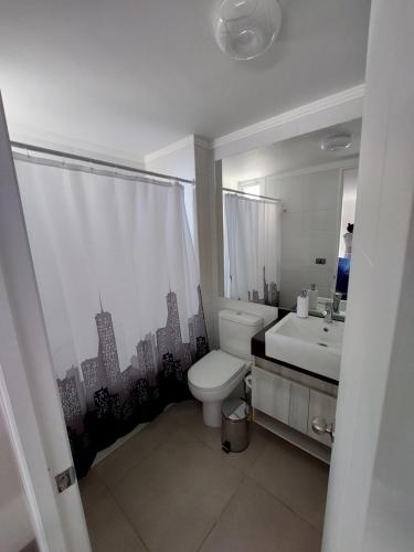 ein Badezimmer mit einer weißen Toilette und einem Waschbecken in der Unterkunft Departamento Coquimbo - La Serena in Coquimbo