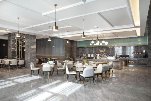 a rendering of a restaurant with tables and chairs at Atour Hotel Hotan Unity Plaza in Hoten