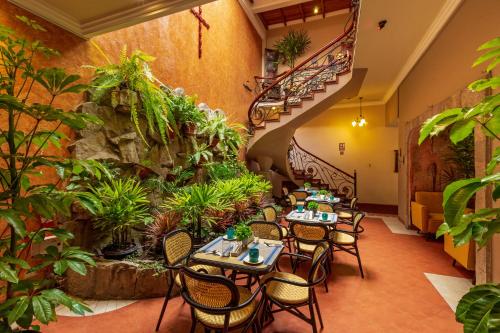 a restaurant with tables and chairs and a staircase at Hotel Posada del Rey in Cuenca