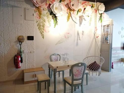 comedor con mesa, sillas y flores en la pared en Setia Tri-Suite, en George Town