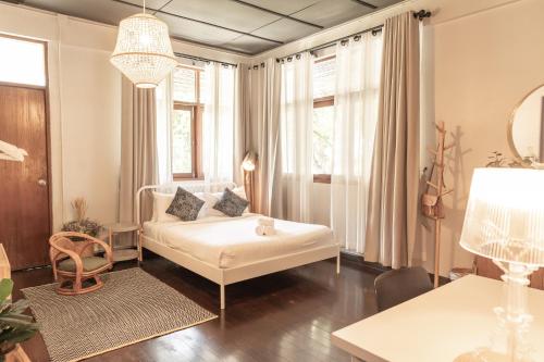 a living room with a white couch and windows at A Day Villa Chiangmai in Chiang Mai