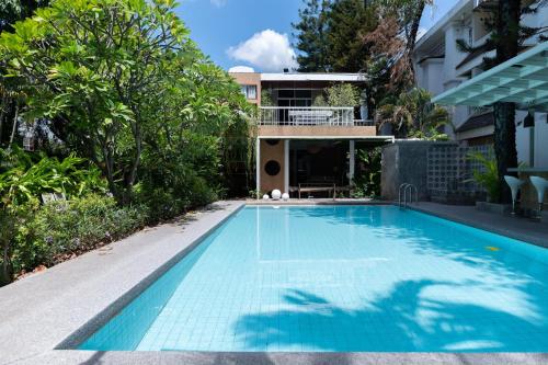 a swimming pool in front of a house at A Day Villa Chiangmai in Chiang Mai