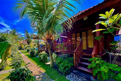 Lembongan Tropical Guesthouse في نوسا ليمبونغان: منتجع به درج يؤدي إلى المنزل
