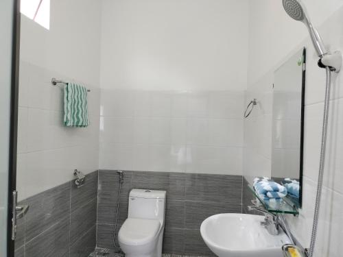 La salle de bains est pourvue de toilettes et d'un lavabo. dans l'établissement Ngua Bay Hotel, à Sa Pa