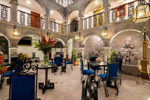 un restaurante con mesas y sillas y una estatua en Hotel Hacienda Cusco Centro Historico, en Cusco