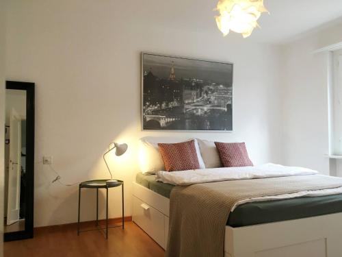 um quarto com uma cama com uma fotografia na parede em 2 Zimmer mit Balkon, zentrale ruhige Lage em St. Gallen