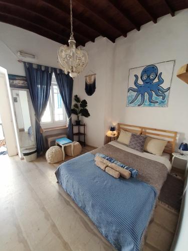a bedroom with a bed and an octopus painting on the wall at Octopus Blue in Mýkonos City
