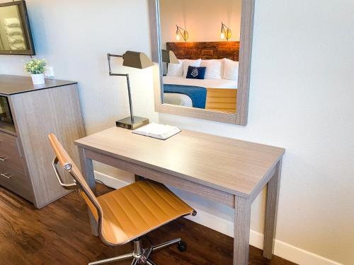 a desk in a room with a bed and a mirror at PINEMARK Inn Suites Events in Saint Clair